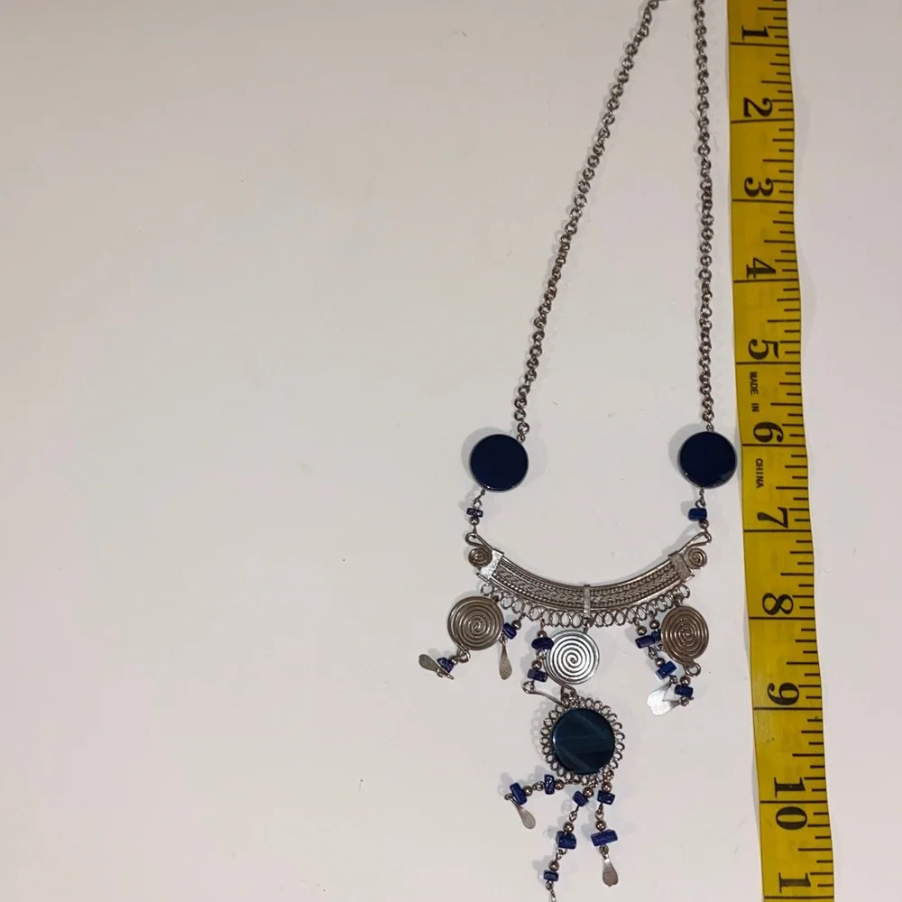 Ornate Silver-Toned Necklace with a Curved Center Adorned with Blue/Black Stones